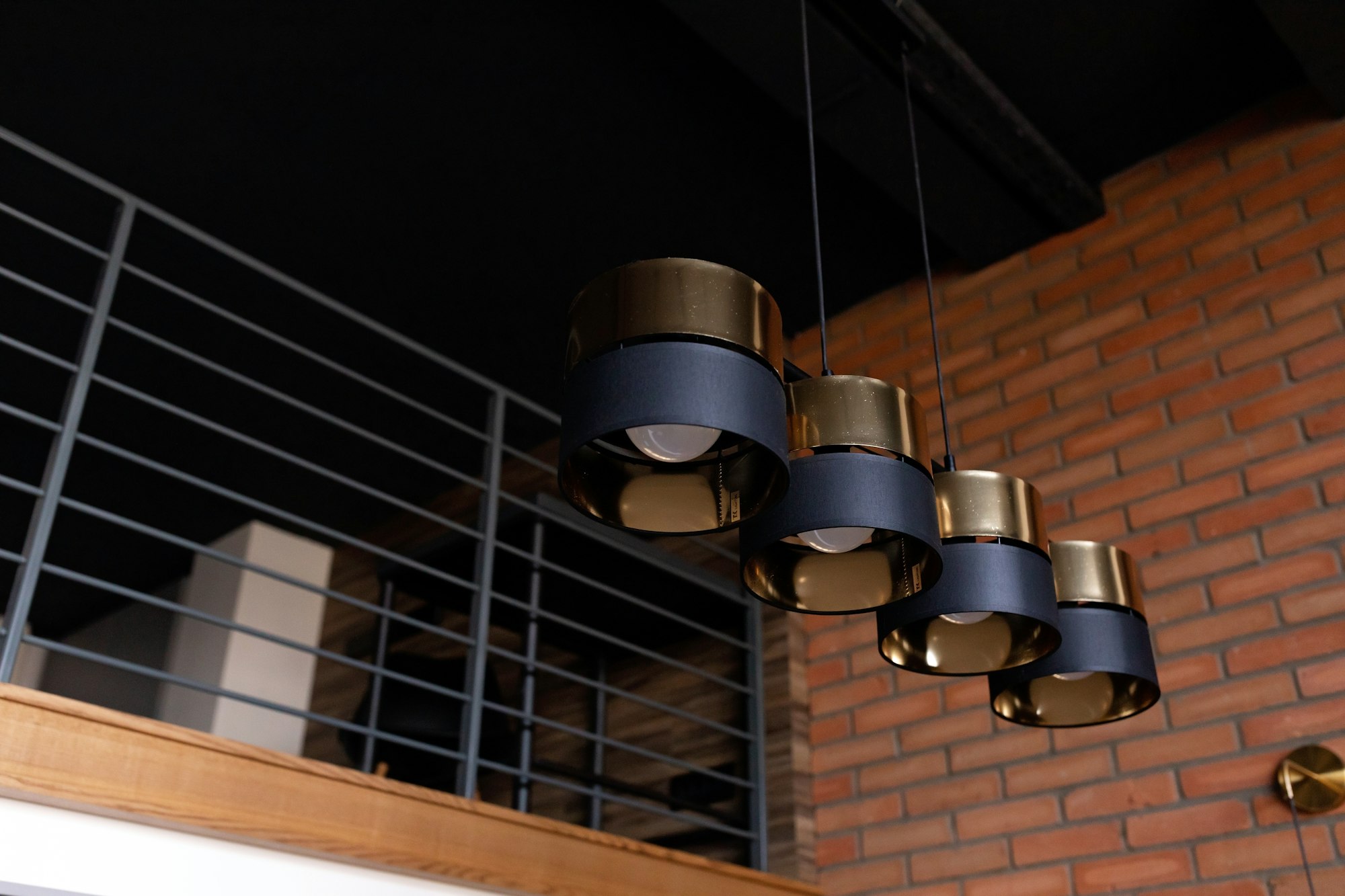 Modern lighting equipment, ceiling lamps in black and gold metal, in a designer loft interior.